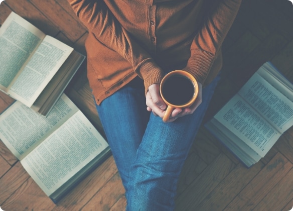 kopje koffie tussen de boeken, creatief moment bij het schrijven